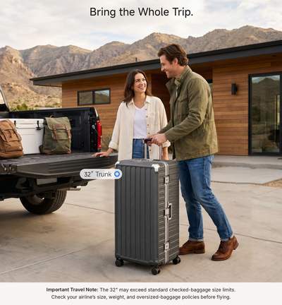 Two LUGGEX 32-inch black zipperless aluminum frame trunk luggage pieces loaded in a pickup truck bed, with a warning that 32-inch size may exceed some airline size limits.#color_charcoal #show