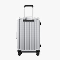Side view of 24'' aluminum frame trunk luggage with a 4:6 trunk structure and protective foot pads that prevent scratches and wear when placed on the ground.  