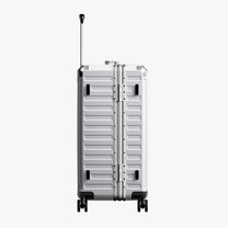 Side view of 24'' aluminum frame trunk luggage with a 4:6 trunk structure and protective foot pads that prevent scratches and wear when placed on the ground.  