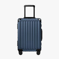 Side view of aluminum frame luggage with protective foot pads that elevate the shell and prevent scratches when the suitcase is placed on the ground. #show #color_navy_blue