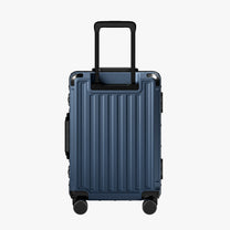 Side view of aluminum frame luggage with protective foot pads that elevate the shell and prevent scratches when the suitcase is placed on the ground. #show #color_navy_blue
