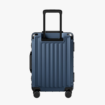 Side view of aluminum frame luggage with protective foot pads that elevate the shell and prevent scratches when the suitcase is placed on the ground. #show #color_navy_blue