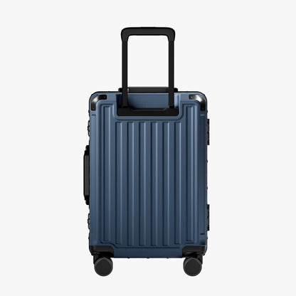 Side view of aluminum frame luggage with protective foot pads that elevate the shell and prevent scratches when the suitcase is placed on the ground. #show #color_navy_blue