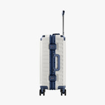 Side view of aluminum frame luggage with protective foot pads that elevate the shell and prevent scratches when the suitcase is placed on the ground. #show #color_white_blue