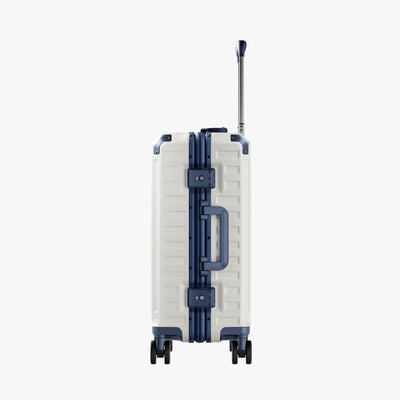 Side view of aluminum frame luggage with protective foot pads that elevate the shell and prevent scratches when the suitcase is placed on the ground. #show #color_white_blue