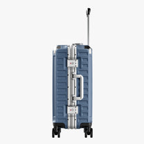 Side view of aluminum frame luggage with protective foot pads that elevate the shell and prevent scratches when the suitcase is placed on the ground. #show #color_blue