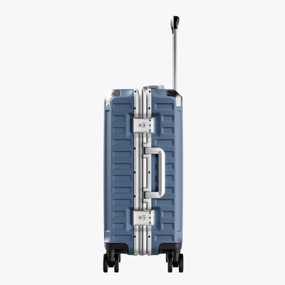 Side view of aluminum frame luggage with protective foot pads that elevate the shell and prevent scratches when the suitcase is placed on the ground. #show #color_blue