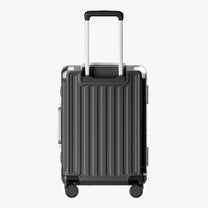 Side view of aluminum frame luggage with protective foot pads that elevate the shell and prevent scratches when the suitcase is placed on the ground. #show #color_charcoal