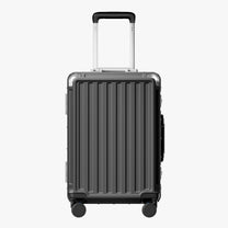 Side view of aluminum frame luggage with protective foot pads that elevate the shell and prevent scratches when the suitcase is placed on the ground. #show #color_charcoal