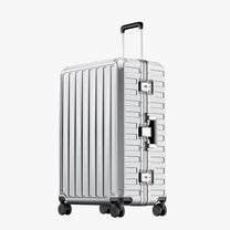 Exploded view of aluminum frame luggage showing 100% polycarbonate shell, reinforced corner protectors, TSA-approved locks, aluminum frame structure, and 360-degree shock-absorbing spinner wheels. 