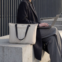 LUGGEX 15.6” laptop tote bag used in a professional work setting, shown beside a laptop outdoors. 
