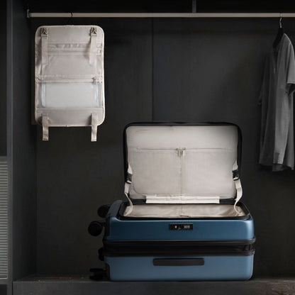 LUGGEX FLO 5 suitcase with removable interior divider hanging in closet, showing detachable organizer and spacious suitcase compartment 
