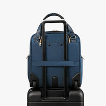 Back view of a 16-inch underseat carry-on luggage with a built-in luggage strap, designed to securely attach to a suitcase handle for hands-free travel. #show #color_blue